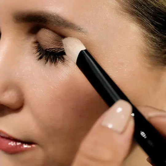 Brushing eyeshadow onto a closed eyelid